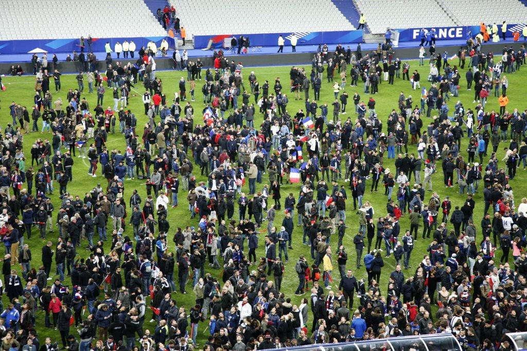 spectators wait on the pitch of the stade de france stadium in seine-saint-denis, paris' suburb on november 13, 2015 after a series of gun attacks occurred across paris as well as explosions outside the national stadium where france was hosting germany. at least 18 people were killed, with at least 15 people had been killed at the bataclan concert hall in central paris, only around 200 metres from the former offices of charlie hebdo which were attacked by jihadists in january. afp photo / matthieu alexandre