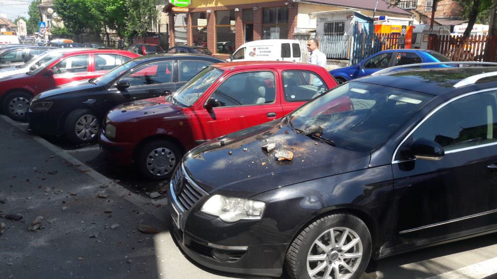 UPDATE VIDEO FOTO – Mașini avariate de bucăți căzute de pe o clădire pe strada Ioan Rațiu