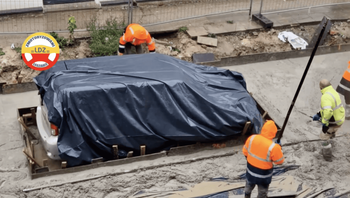 mașină ”îngropată” în asfalt. muncitorii au acoperit-o cu folie și au trurnat beton în jurul ei (video)