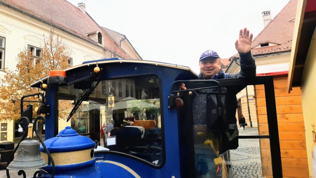 șoferul care face fericiți toți turiștii la sibiu. ghiță îi plimbă cu trenulețul lui moș crăciun prin centrul istoric. „cel mai greu este că nu sunt acasă”