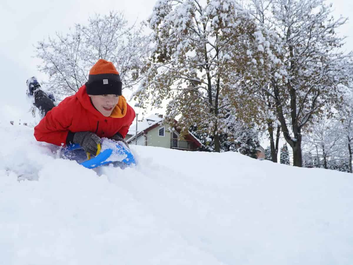 imagini de basm din parcul sub arini, acoperit de zăpadă. copiii au mers la derdeluș